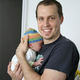New father Dan Rudloff tries to express joy while realizing he will never ever be able to get that boat.